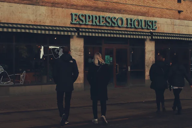 People walking past Espresso House in Gothenburg, Sweden. Street photography with a focus on urban lifestyle. Förstå stadsdelens företagsliv och lokala marknad